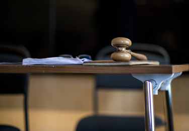 Foto av ett bord och en stol. På bordet ligger en mötesklubba.